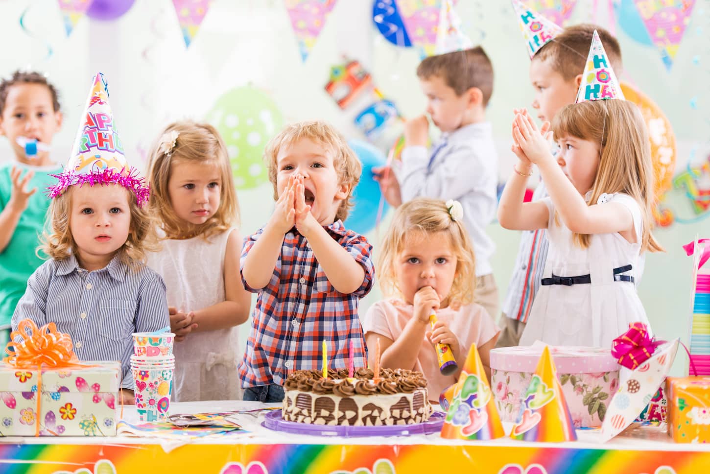 Gruppe von fröhlichen Kindern feiert einen Kindergeburtstag